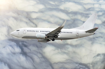 Passenger airplane flies in the sky gaining height above the clouds