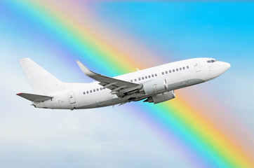 Climbing airplane against a rainbow in the sky