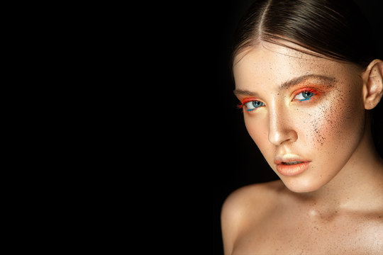 Beautiful woman portrait with colorful make up in bronze colors and splashes on face.