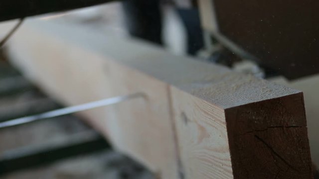 Industrial band-saw cutting timber into planks
