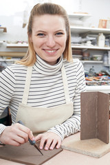 Portrait Of Young Woman Making Pot in Ceramics Studio