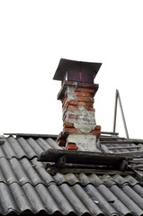 Naklejka premium Breaking furnace chimney, made of red brick, on the roof of the old village house