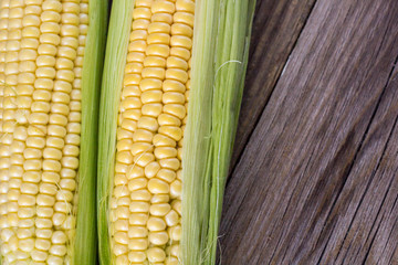 Fresh corn on cobs on rustic wooden table, closeup, top view, copy space