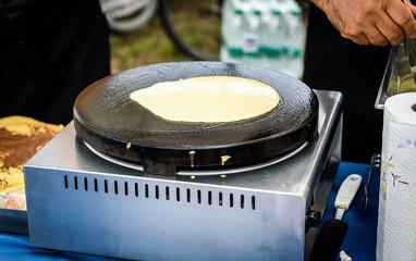 Making of crepes pancakes in open market festival fair.
