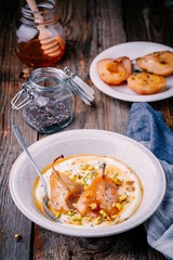 Healthy breakfast bowl: yogurt with caramelized pears, pistachios, honey and chia seeds