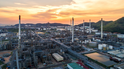 Obraz premium Aerial view Oil refinery.Industrial view at oil refinery plant form industry zone with sunrise and cloudy sky.Oil refinery and Petrochemical plant at dusk,Thailand.