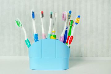 many toothbrushes in a glass