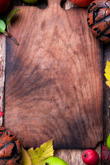 Jack-o-lantern around empty cutting board on wooden background. Autumn concept. Halloween. Top...