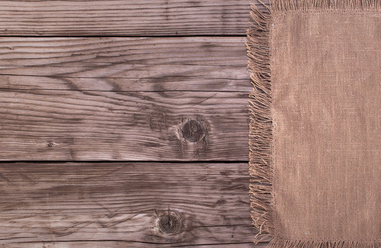 Brown cotton napkin from right side of old wooden background top view