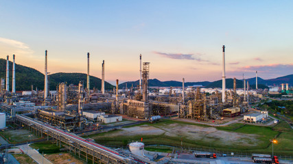 Obraz premium Aerial view Oil refinery.Industrial view at oil refinery plant form industry zone with sunrise and cloudy sky.Oil refinery and Petrochemical plant at dusk,Thailand. Oil refinery background sunset.