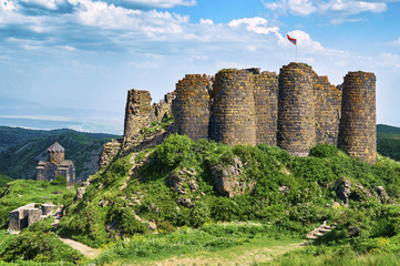 Beautiful medieval fortress Amberd in Armenia with armenian flag on the top swaying in the wind  