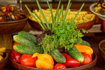 Тарелка с свежими спелыми овощами на столе 