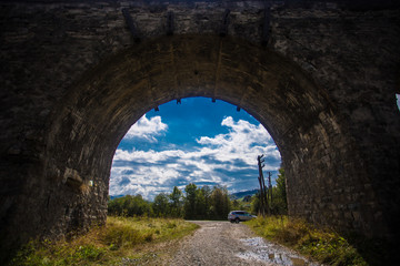 Fototapeta na wymiar Old tunnel of historical stone railway bridge with light in the end