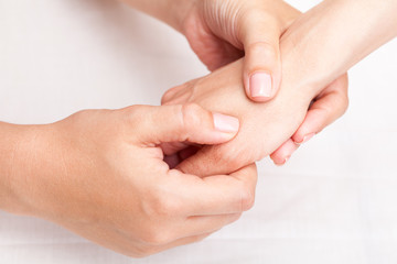 Fototapeta na wymiar Woman receiving osteopathic treatment of her thumb