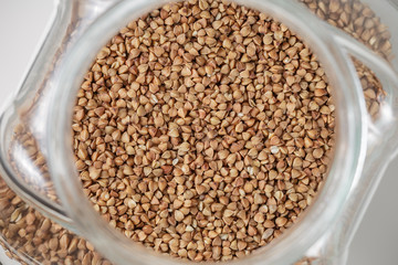 Uncooked up of raw buckwheat in glass jar