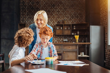 Radiant elderly lady listening to grandson at home