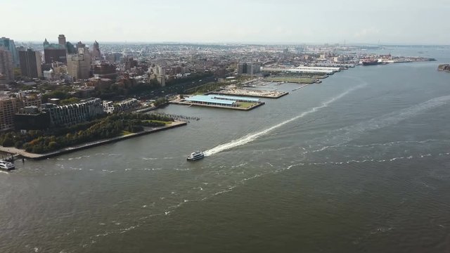 Aerial view of the East river, boat riding through the water near the downtown of Brooklyn in New York, America.