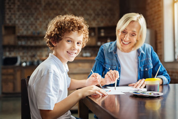 Excited curly haired child enjoying spending time with granny