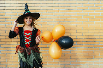 Portrait of beautiful girl disguised of witch in the street.