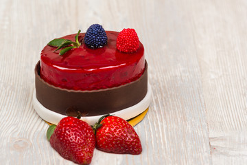 The chocolate glaze cake and strawberry on the table