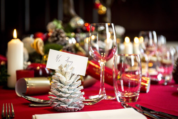 A christmas table ready for lunch with place settings, decorations and candles