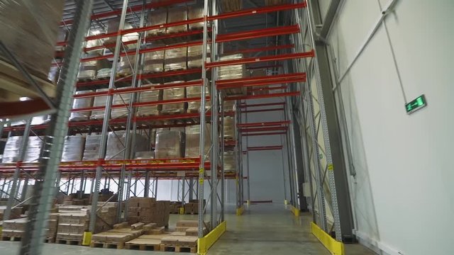 Logistic warehouse, movement of the chamber between the shelves in the warehouse, shelves and racks with boxes.
