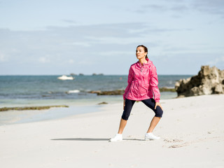 Young woman at the beach doing exercises