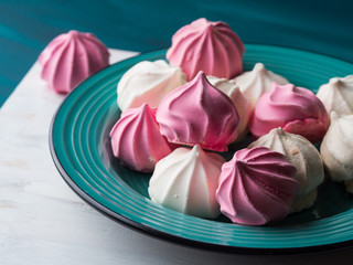 Pastel color pink and white meringue on green background