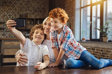 Smiling children and granny taking phones together