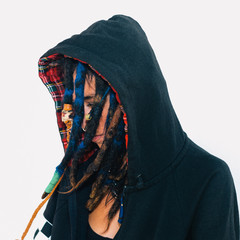 Model in a sweatshirt with dreadlocks and piercings. Fashion accessories. Street style