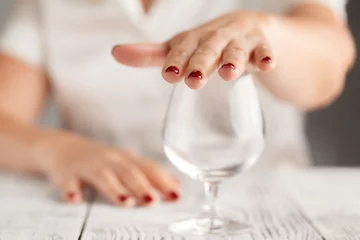 Rolgordijnen Bar Bijgesneden afbeelding van een vrouw die een stopgebaar toont en weigert te drinken