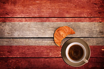 Cup of coffee with croissant and flag