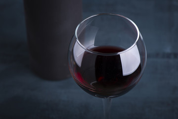 Pouring red wine into the glass against wooden background