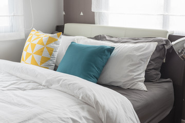 colorful pillows on white bed in modern bedroom