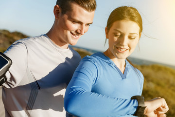 Runner woman with heart rate monitor running on beach