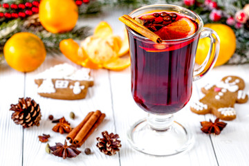 Christmas mulled wine with spices in cup on wooden background