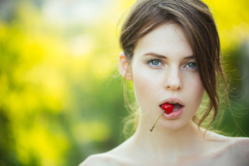 Girl with cherry berry in mouth