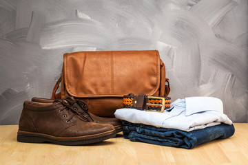 Asian vintage style men clothing and jeans and bag put on wooden table and loft concrete wall texture background.