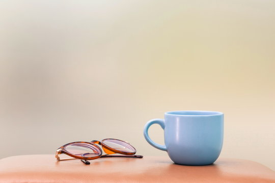 blue cup and eyeglass on the table