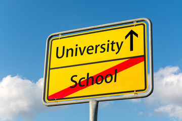 Obraz premium Yellow street sign with university ahead leaving school behind