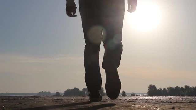 The man at sunset - dawn is walking on the roof and sits on its edge. He enjoys nature and thinks about his feelings for life. He is inspired and motivated.
