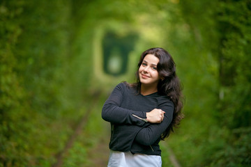 Beautiful woman in Natural tunnel of love formed by trees.