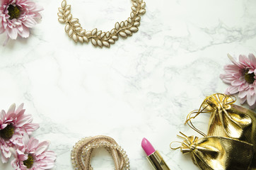 Flowers with feminine accessories lie on a marble background