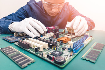 The technician is putting the CPU on the socket of the computer motherboard. the concept of...
