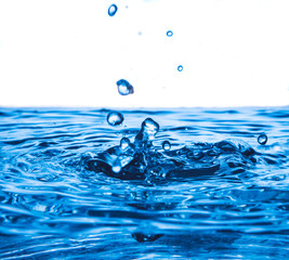 Water drop splash on water surface, Blue wave and bubbles background.