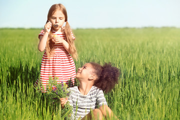 Happy little girls in green field