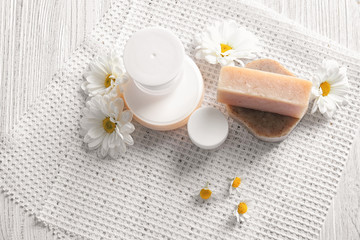Obraz na płótnie Canvas Composition with skin care products and chamomile flowers on wooden table