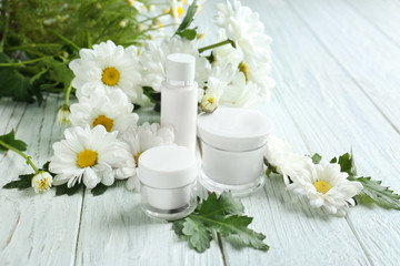 Fototapeta na wymiar Composition with skin care products and chamomile flowers on wooden table