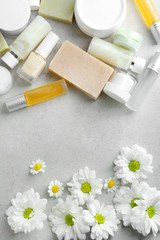 Composition with skin care products and chamomile flowers on table
