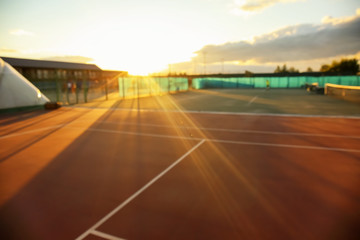 Fototapeta premium Tennis court at sunset, blurred view